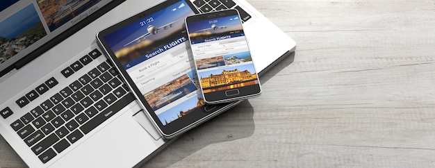 Smartphone and tablet on a computer keyboard Search flights on the screens wooden background copy space 3d illustration