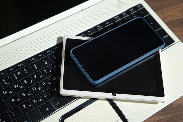 Smartphone tablet laptop computer on the wooden table