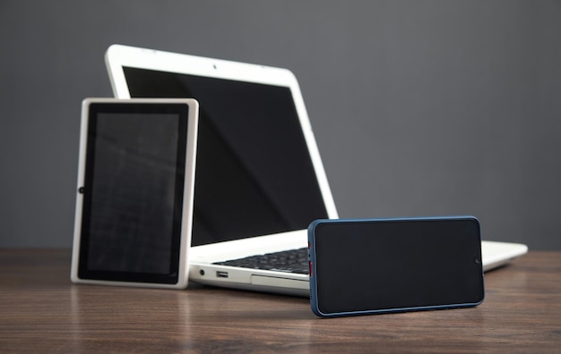 Photo smartphone tablet laptop computer on the wooden table