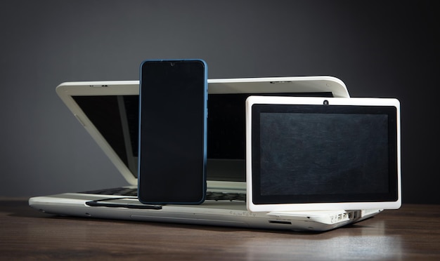 Smartphone tablet laptopcomputer op de houten tafel