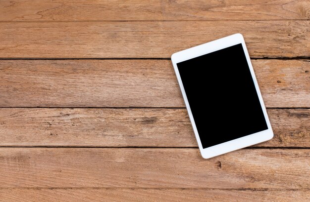 Smartphone and tablet with black screen on old wooden background