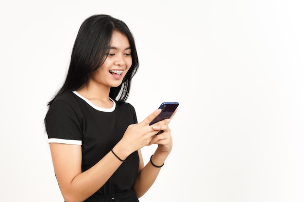 Smartphone vasthouden of gebruiken en glimlach van mooie Aziatische vrouw geïsoleerd op een witte achtergrond