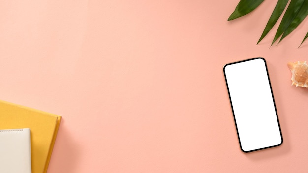 파스텔 핑크 배경에 일기 액세서리와 복사 공간이 있는 스마트폰 흰색 화면 모형