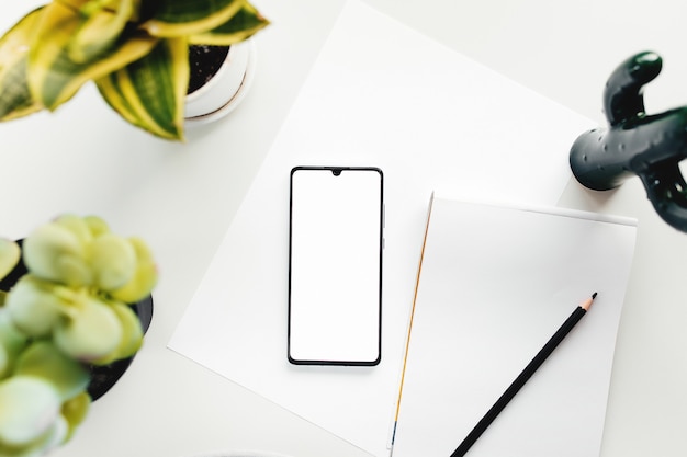 Smartphone on white table, work from home, office stuff. High quality photo