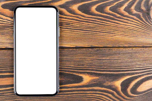 空白の画面がモックアップされたスマートフォン。クリッピングパスとスマートフォンの分離画面。オフィスデスクのコピースペースと携帯電話の白い画面。テキスト用の空のスペース。孤立した白い画面