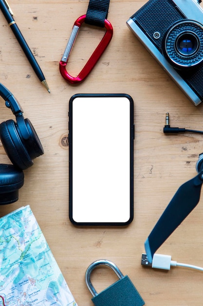 smartphone with blank screen surrounded by adventure equipment