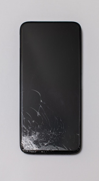 Photo smartphone with a broken screen vertically on a gray background