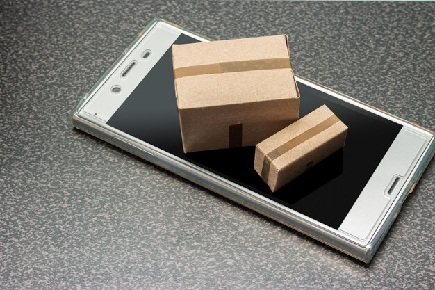 Фото Смартфон с картонными коробками концепция интернет-покупок