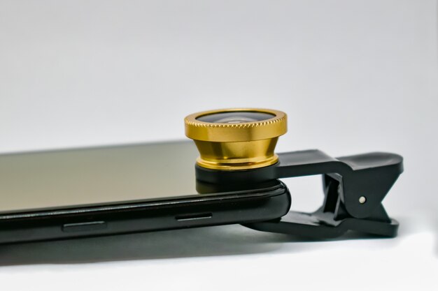 Smartphone with lens on clip. an external wide-angle lens and\
clip are supplied with mobile phone