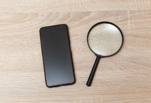 Photo smartphone with magnifier on wooden table