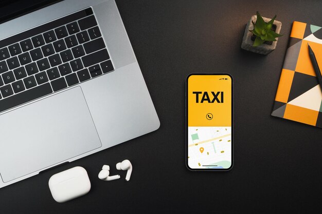 Smartphone with Taxi Service app on the screen on black background table. Office environment. Mobility service provider worldwide.