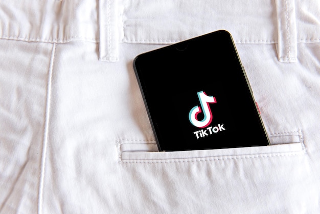 Smartphone with tiktok application in white jeans pocket