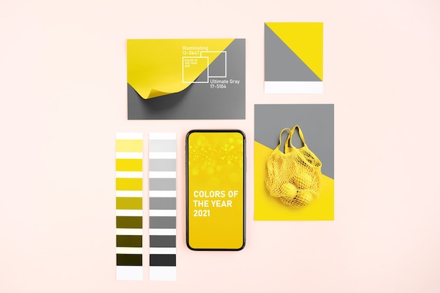 Smartphone with Ultimate Grey and Illuminating colors of the year 2021  and fashion colour swatches. Collage with color trend palette.