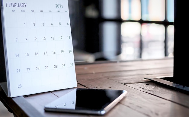 Smartphones en kalenders op een donkere houten tafel zijn een creatief concept