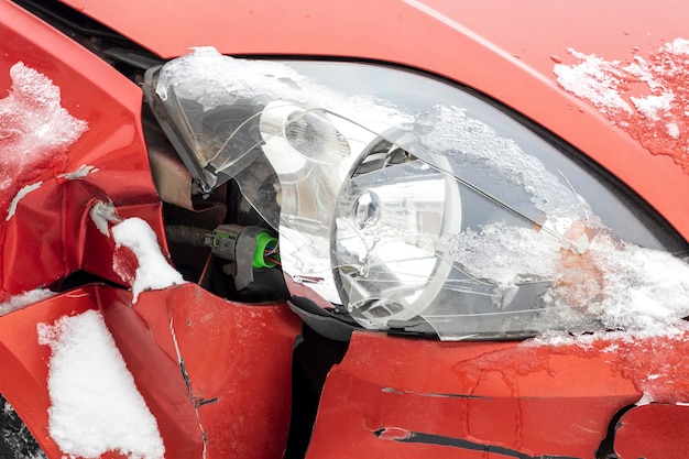 壊された赤い車。車のひびの入ったヘッドライト。高品質の写真