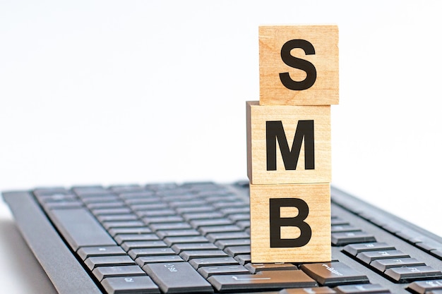 Photo smb in 3d wooden alphabet letters on a keyboard surface