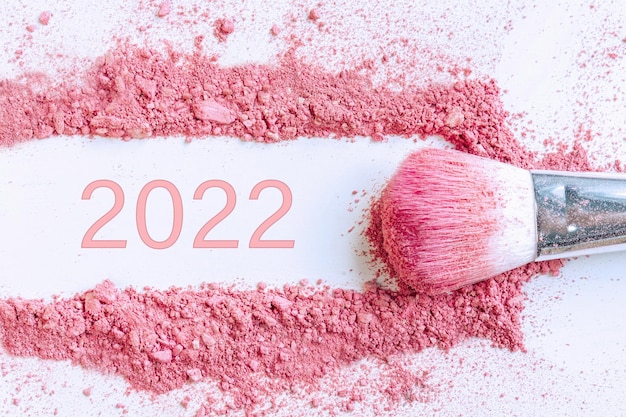 Smear of crushed pink blush on as sample of cosmetics product with 2022 number copy space