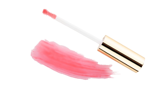 Smear of pink lip gloss and brush on a white