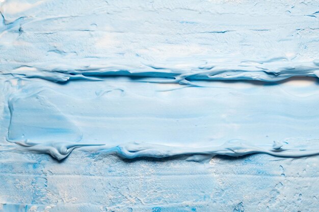 Photo smeared blue and white acrylic paint background tooth paste effect abstract surface