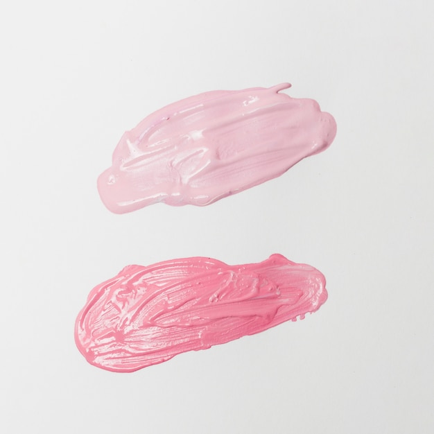 Smears of pink lipsticks on gray background