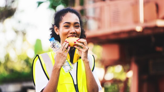 Smile African american for relaxing eats bread snacks and water during brunch break