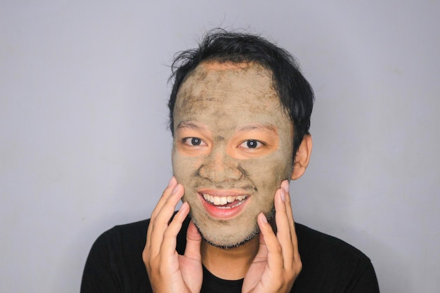 Smile Asian Man was happy at the camera when he use beauty face mask