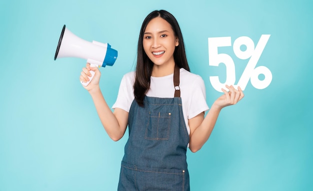 Smile Asian woman wear on an apron and holding megaphone with showing 5% on blue background.