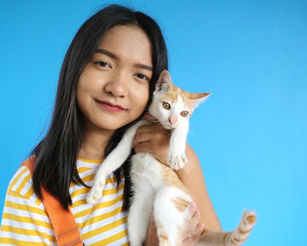 Smile beautiful girl with lovely cat on blue background.