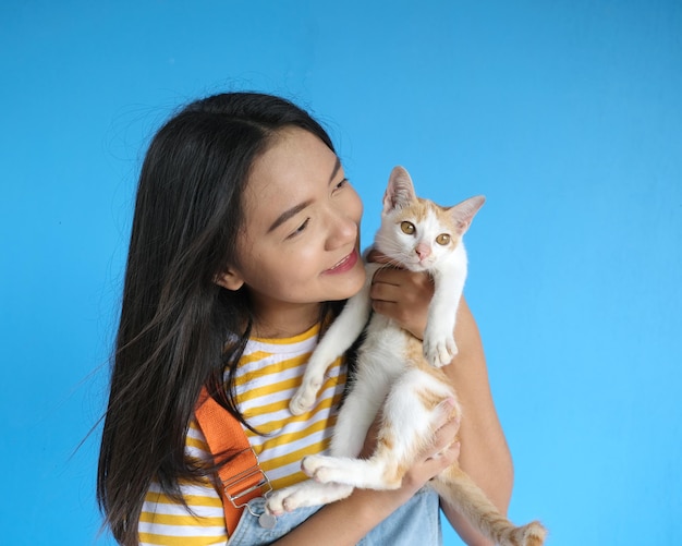 Smile beautiful girl with lovely cat on blue background.