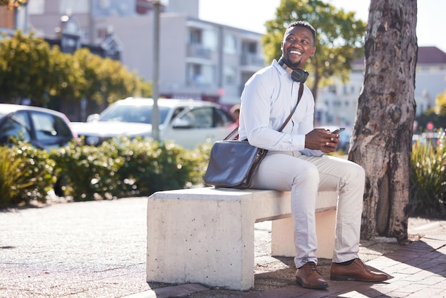 smile black man and phone for commute outdoor with headphones texting and browsing social media for travel happy african and male person with mobile for communication transport location and city