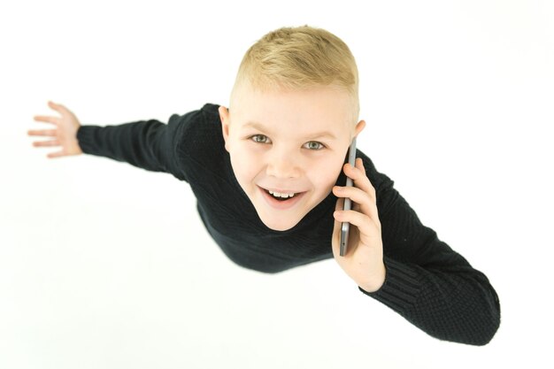Телефон мальчика улыбки на белом фоне. Вид сверху
