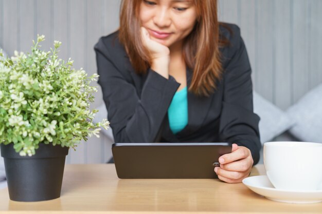 Smile business woman in black suit using tablet at office