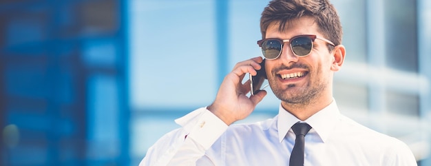 The smile businessman in sunglasses phone