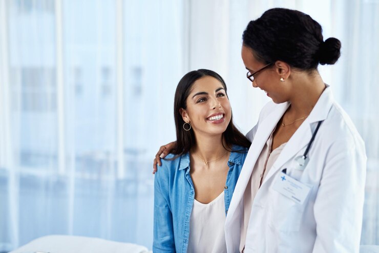 Photo smile doctor and hug woman at hospital for consultation discussion support and medical advice of fertility report happy patient and healthcare worker for empathy comfort and exam results of help