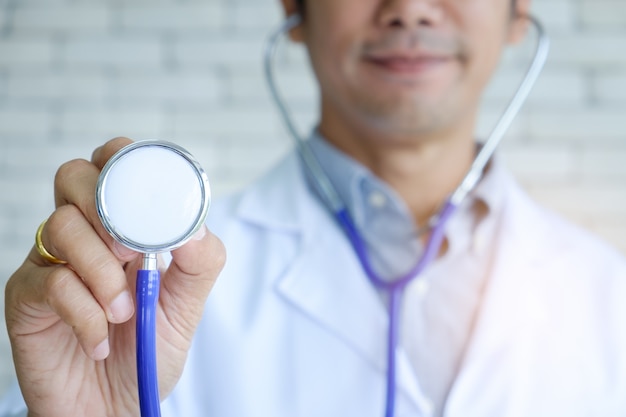 Smile Doctor Man Hand holding purple stethoscope for Good Health check