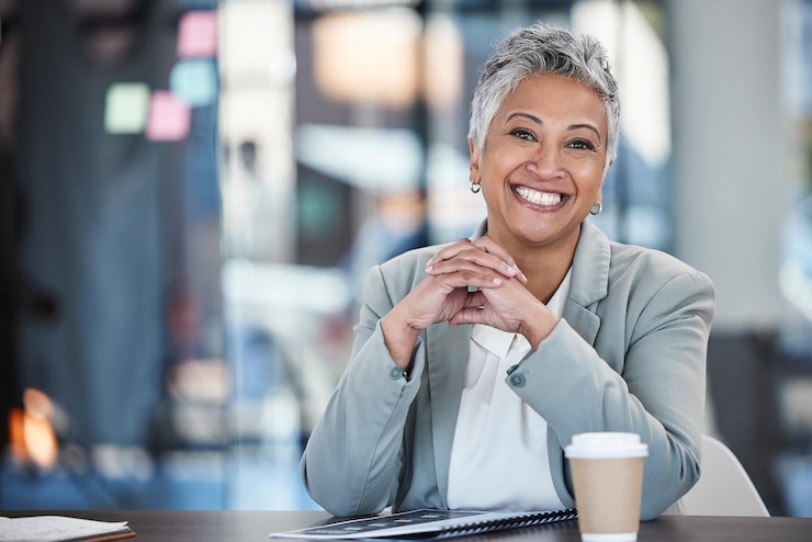Photo smile executive and portrait of a woman in business for working success and goals corporate happy and mature office employee sitting at a desk to start work in the morning at a legal company