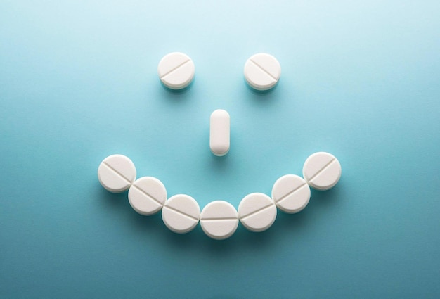 Smile face from pills on blue background