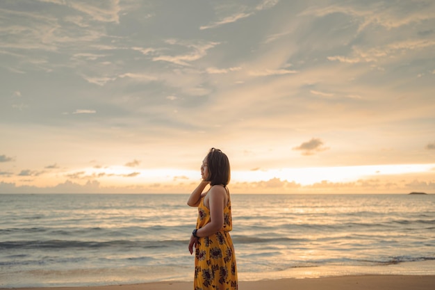 写真 ビーチで笑顔の自由と幸福アジアの女性彼女は旅行中に穏やかな海の自然を楽しんでいます