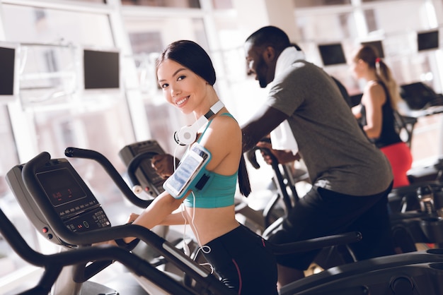 Sorriso ragazza in palestra si concentra sulla corsa