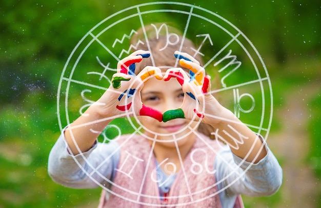 Smile on the hands of a child drawing zodiac sign Selective focus