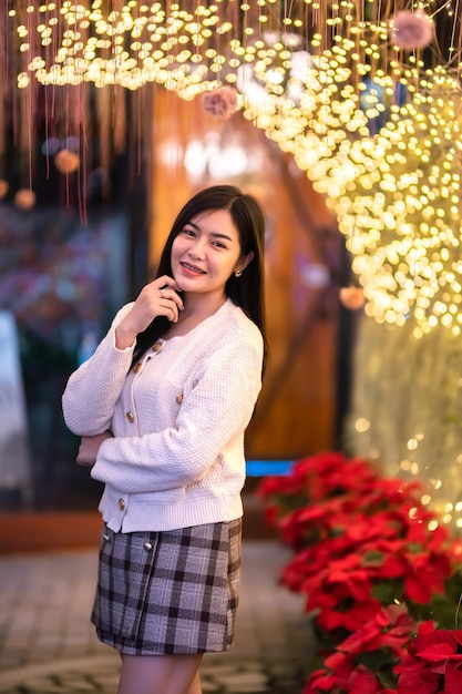 Smile happiness portrait beautiful young asian woman wearing warm clothes Decoration During Christmas xmas and New Year holidays at light circular bokeh background