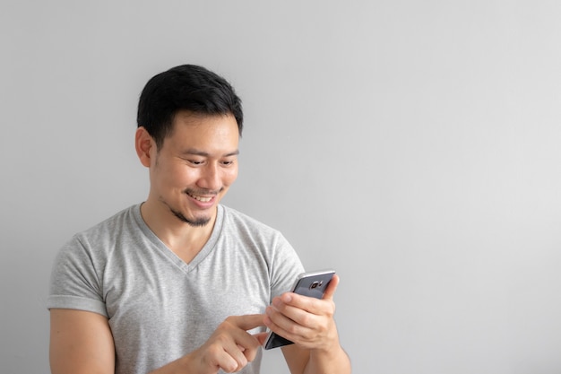 Smile and happy face of man use and touch his smartphone.