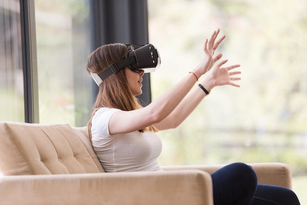 Smile happy woman getting experience using VR-headset glasses of virtual reality at home