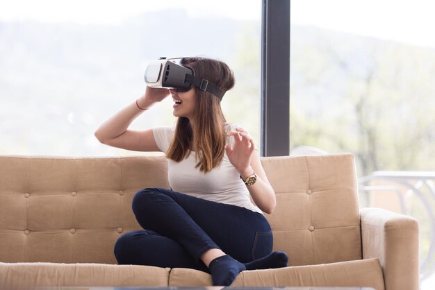 Smile happy woman getting experience using VR-headset glasses of virtual reality at home