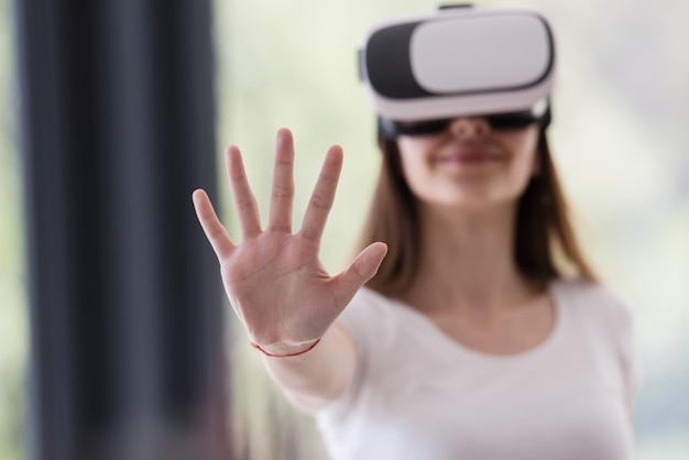 Sorridi donna felice che fa esperienza con gli occhiali vr-headset della realtà virtuale a casa