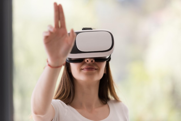 Улыбка счастливая женщина, получающая опыт использования очков виртуальной реальности VR-гарнитуры дома