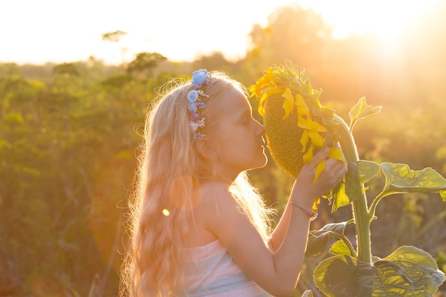 Sorridi bambina con girasole all'ora del tramonto