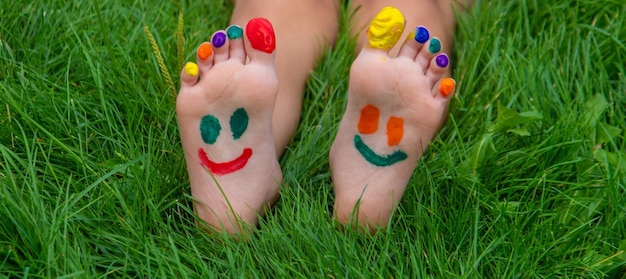 子供の手足に絵の具で描かれた笑顔