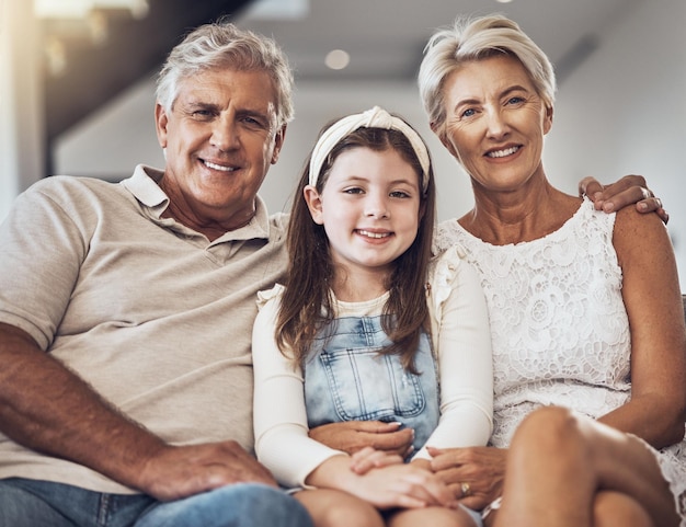 Улыбающийся портрет или бабушка и дедушка обнимают девушку в гостиной, сближаясь как семья в Австралии с любовью Выход на пенсию счастливый или пожилой мужчина расслабляет старуха с ребенком дома вместе на веселом отдыхе