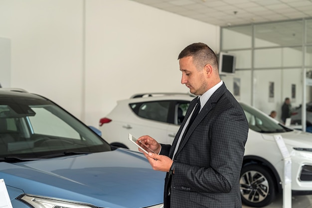 新車ショールームで一人で笑顔のセールスマンやクライアント コンセプト自動車の販売やレンタル